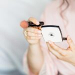 Macchie di fondotinta su un tessuto, con materiali per la pulizia accanto.