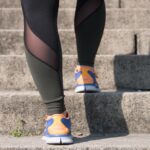 Immagine di una persona che sale le scale, evidenziando il dolore al ginocchio durante il movimento.