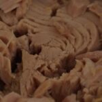 Immagine di una lattina di tonno con un'etichetta che evidenzia la marca controversa.